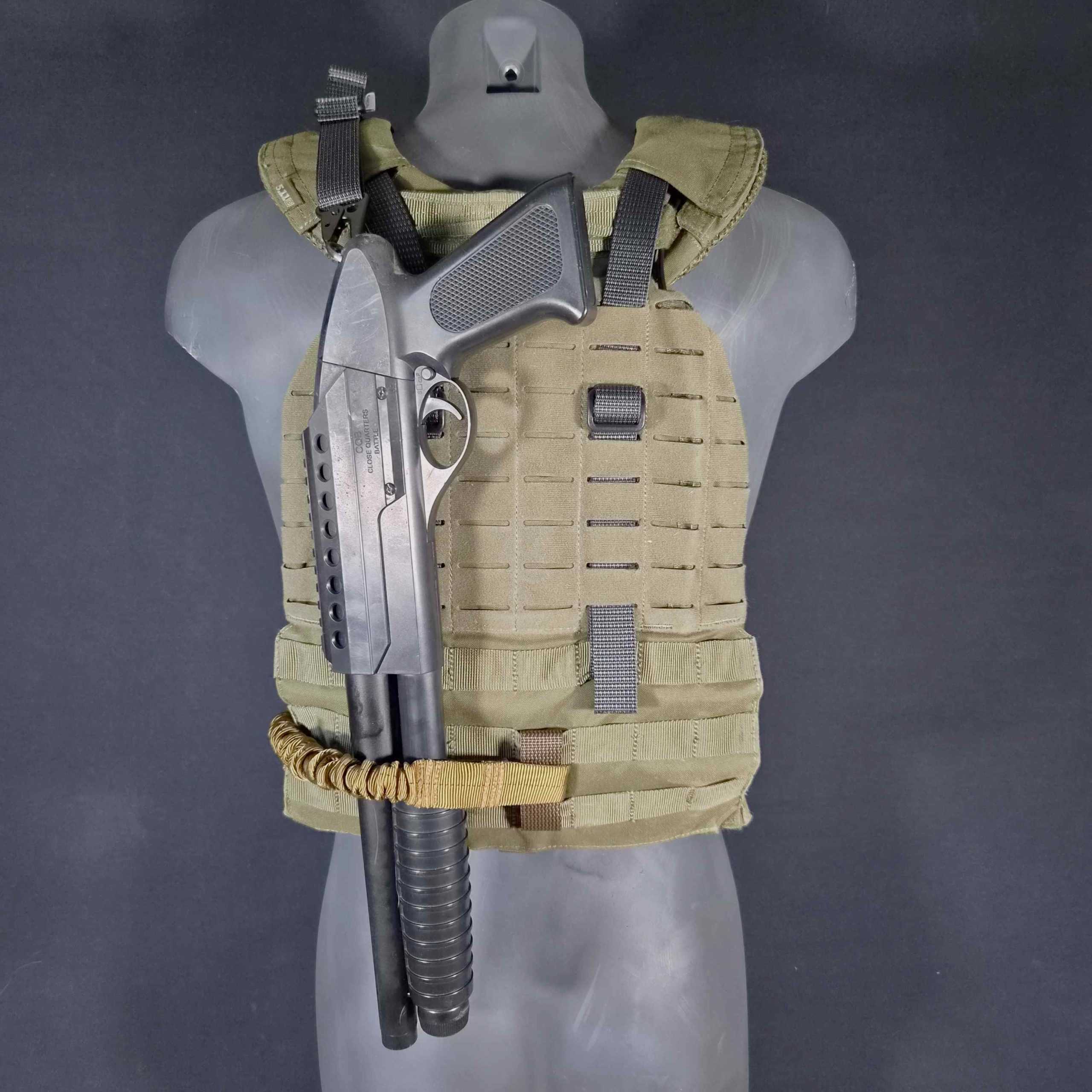 breaching shotgun on a back of a plate carrier.